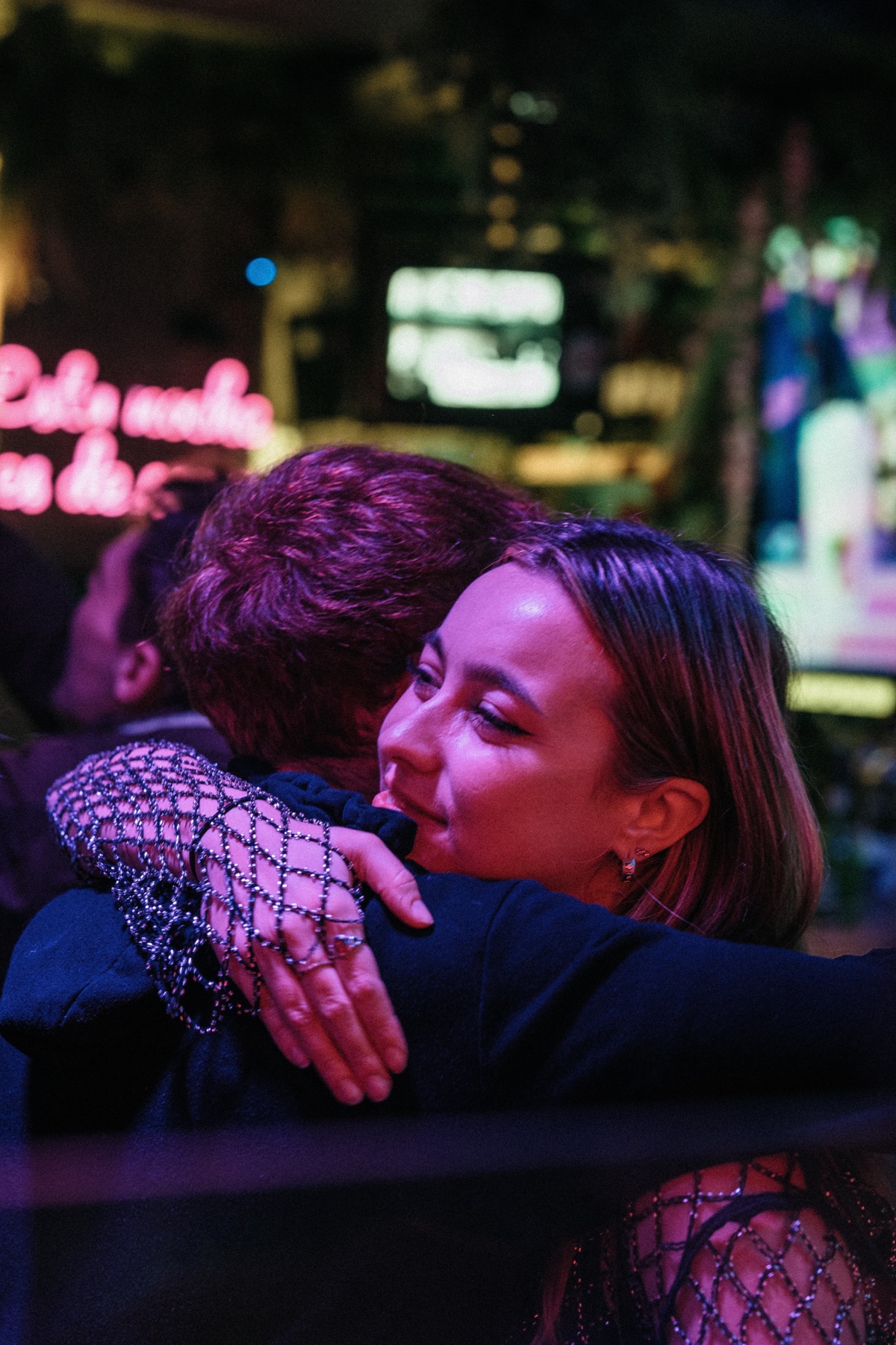 Friends embracing during a night at Copas